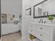 Bathroom with vanity, large mirror, and view of bedroom at 1581 Amberlea S Dr, Dunedin, FL 34698