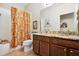 Bathroom boasts double sinks, granite countertops, and a vintage shower curtain at 15811 Oakleaf Run Dr, Lithia, FL 33547