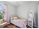 Charming bedroom with a twin bed, sitting chair, and full-length mirror at 15811 Oakleaf Run Dr, Lithia, FL 33547