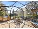 Spacious screened patio with outdoor kitchen and dining furniture at 15811 Oakleaf Run Dr, Lithia, FL 33547