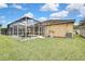 Landscaped backyard with a screened pool and spacious grassy area at 19820 Morden Blush Dr, Lutz, FL 33558