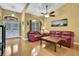 Living room with hardwood floors, leather couches, and ceiling fan at 19820 Morden Blush Dr, Lutz, FL 33558