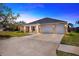 Brick house with a three-car garage and manicured lawn at 2402 Cumberland Cliff Dr, Ruskin, FL 33570