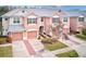 Aerial view of townhouses with two-car garages, landscaping, and brick pavers at 26519 Castleview Way, Wesley Chapel, FL 33544
