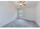 Spacious bedroom with grey carpet, window, and ceiling fan at 26519 Castleview Way, Wesley Chapel, FL 33544