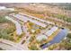 Aerial view of community with townhouses, pond, and lush landscaping at 26519 Castleview Way, Wesley Chapel, FL 33544
