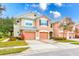 Two story townhome with peach exterior, two car garage, and landscaping at 26519 Castleview Way, Wesley Chapel, FL 33544