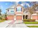 Two-story townhome with peach-colored exterior, two-car garage, and landscaped front yard at 26519 Castleview Way, Wesley Chapel, FL 33544