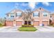 Front view of three-unit townhouse building with garages at 26519 Castleview Way, Wesley Chapel, FL 33544
