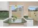 Bright kitchen features white cabinets, green countertops, and a breakfast bar at 2736 Haverhill Ct # 2736, Clearwater, FL 33761