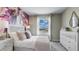Bright bedroom with a stylish bed, dresser, and large window at 31283 Midnight Sun Way, Wesley Chapel, FL 33545