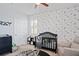 Bedroom with Star Wars decor, crib, and comfy chair at 3238 Mela Ct, Holiday, FL 34691