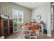 Charming dining room with patterned wallpaper and rustic farmhouse table at 3238 Mela Ct, Holiday, FL 34691