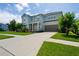 Two-story light blue house with a gray roof, landscaping, and driveway at 3238 Mela Ct, Holiday, FL 34691