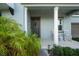 Front porch with rocking chairs, columns, and lush landscaping at 3238 Mela Ct, Holiday, FL 34691