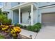 Front porch with rocking chairs, columns, and lush landscaping at 3238 Mela Ct, Holiday, FL 34691
