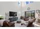 Open concept Gathering room with high ceilings, leather sofas, and a large TV at 3238 Mela Ct, Holiday, FL 34691