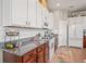 Modern kitchen featuring white cabinets, granite counters, and a herringbone backsplash at 3238 Mela Ct, Holiday, FL 34691