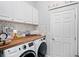 Bright laundry room with washer, dryer and wood countertop at 3238 Mela Ct, Holiday, FL 34691