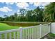 Serene pond with lush landscaping and fence at 3238 Mela Ct, Holiday, FL 34691