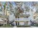 Two-story white building with multiple units and parking at 3270 Haviland Ct # 304, Palm Harbor, FL 34684