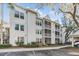 Two-story white building with multiple units and ample parking at 3270 Haviland Ct # 304, Palm Harbor, FL 34684