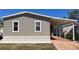 Well-maintained home exterior with vinyl siding, brick foundation, and a covered carport at 3729 Winward Lakes Dr, Tampa, FL 33611