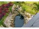 Relaxing aerial view of a koi pond, waterfall, and stone landscaping at 5906 N Kenneth Ave, Tampa, FL 33604
