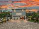 Two-story house with a large paved driveway and landscaped yard at sunset at 5906 N Kenneth Ave, Tampa, FL 33604