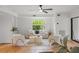 Bright living room with tiled floors, comfy seating, and large window at 5906 N Kenneth Ave, Tampa, FL 33604