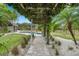 Stone pathway under a pergola leading to a refreshing pool and backyard at 5906 N Kenneth Ave, Tampa, FL 33604
