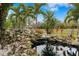 Peaceful pond with waterfall, surrounded by lush tropical plants at 5906 N Kenneth Ave, Tampa, FL 33604