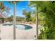 View of kidney-shaped pool through lush landscaping at 5906 N Kenneth Ave, Tampa, FL 33604