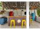 Rustic pool bar with yellow stools and a red fridge at 5906 N Kenneth Ave, Tampa, FL 33604