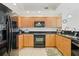 L-shaped kitchen with granite countertops and black appliances at 628 Cleveland St # 1201, Clearwater, FL 33755