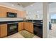 L-shaped kitchen with granite countertops and black appliances at 628 Cleveland St # 1201, Clearwater, FL 33755