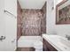Updated bathroom with brown tile, a tub, and a vanity with white countertop at 107 Seahorse Se Dr # A, St Petersburg, FL 33705
