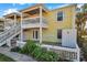 Two-story building with balcony, white railings, and yellow exterior at 107 Seahorse Se Dr # A, St Petersburg, FL 33705