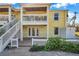 Two-story building with balcony, white railings, and yellow exterior at 107 Seahorse Se Dr # A, St Petersburg, FL 33705