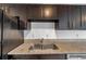 Double stainless steel sink with granite countertop and dark wood cabinets at 107 Seahorse Se Dr # A, St Petersburg, FL 33705