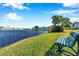 Serene lakefront view with bench and palm trees at 107 Seahorse Se Dr # A, St Petersburg, FL 33705