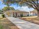 Ranch-style house with carport and mature landscaping at 10930 N Edison Ave, Tampa, FL 33612