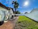 Brick patio and grassy backyard with white fence at 1200 80Th S St, St Petersburg, FL 33707