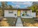 Charming white house with yellow door, landscaped yard, and walkway at 1224 11Th S Ave, St Petersburg, FL 33705