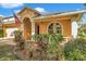 Tan one-story house with a two-car garage and manicured landscaping at 12308 Adventure Dr, Riverview, FL 33579