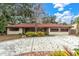 Single-story home with red tile roof, spacious driveway, and lush landscaping at 1545 Park N St, St Petersburg, FL 33710