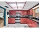 Red kitchen cabinets, skylight, granite countertops, stainless steel appliances at 1545 Park N St, St Petersburg, FL 33710