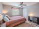 Cozy bedroom with queen-size bed, ceiling fan, and built-in workspace at 1673 Nash Ct, Dunedin, FL 34698