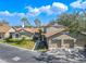 Townhome showcasing a detached garage, well-maintained landscaping, and a serene setting with blue skies and clouds at 1673 Nash Ct, Dunedin, FL 34698