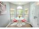 Bright kitchen nook with white table and red chairs at 1673 Nash Ct, Dunedin, FL 34698